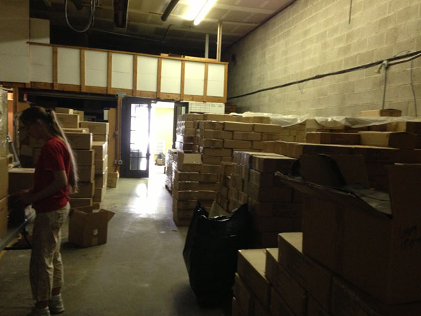 Keliana Tayler, with stacks of boxes full of thousands of books